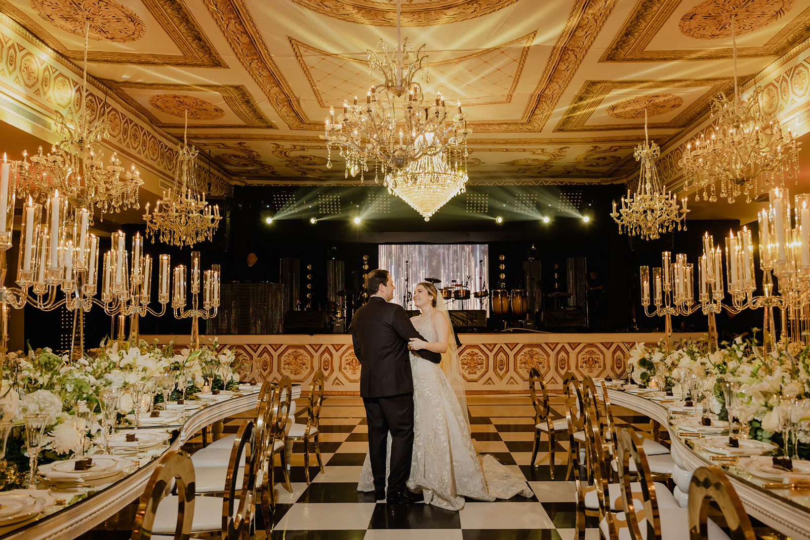 Salón dorado con candelabros y pista ajedrezada