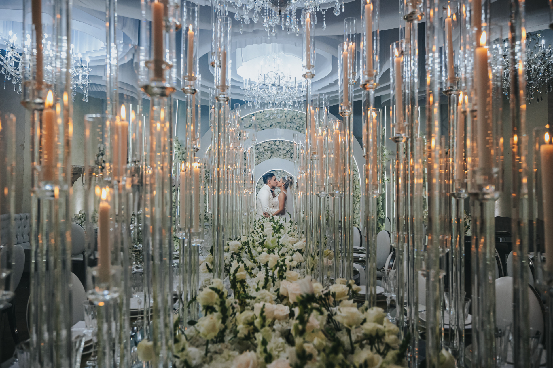 Salón con candelabros de cristal y flores blancas